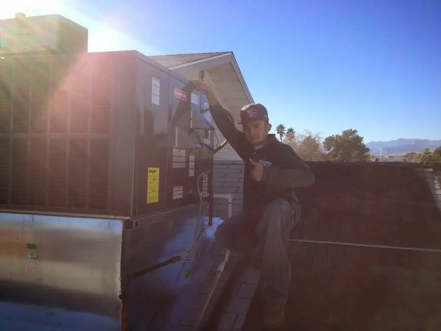 HVAC technician performing Air Duct Cleaning on a rooftop unit in Glenview